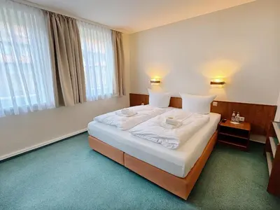 Ein Bett oder Betten in einem Zimmer der Unterkunft REGIOHOTEL Bunte Stadt Wernigerode - #DirektInDerAltstadt #PrimaFrühstück #TopPreisLeistung #FrischRenoviert