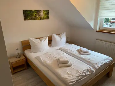 Ein Bett oder Betten in einem Zimmer der Unterkunft Hotel Garni und Gaststätte Zum Holzfäller