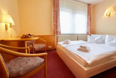 Ein Bett oder Betten in einem Zimmer der Unterkunft HarzHotel Güntersberge